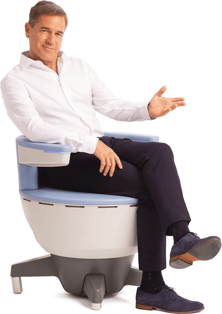 A man seated fully clothed on the Emsella chair